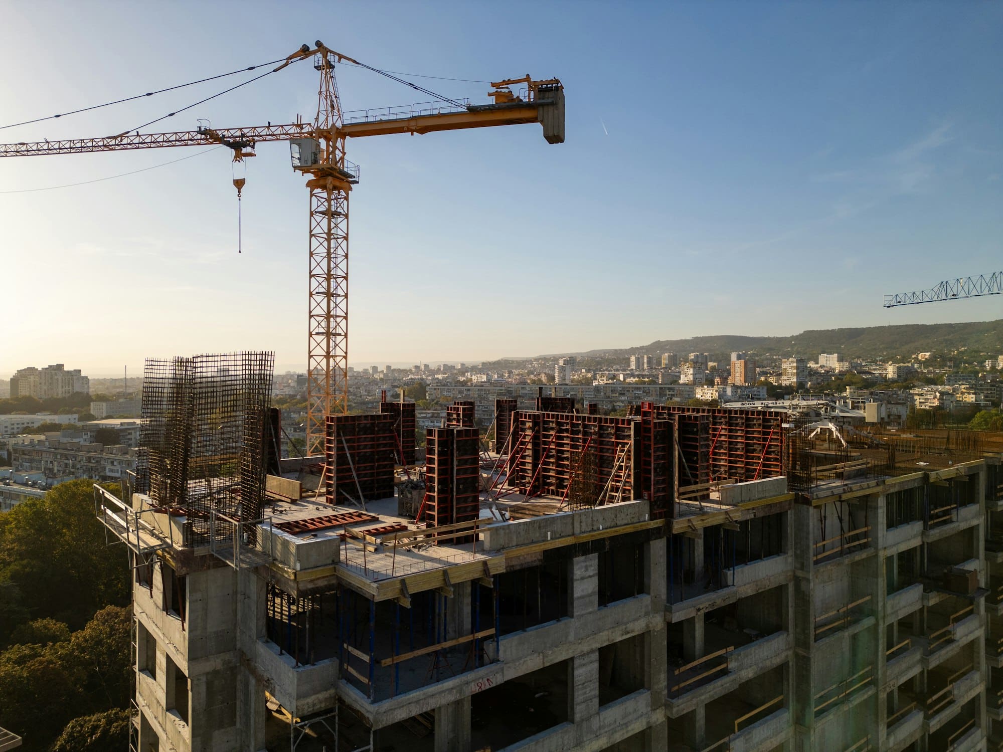 Ferkomedia - A drone video capturing the construction site of a high-rise building at sunset. The structure's