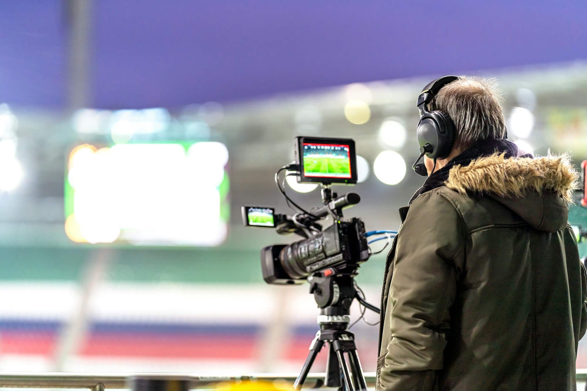 Ferkomedia - cameraman with a professional video camera on the broadcast of a football match