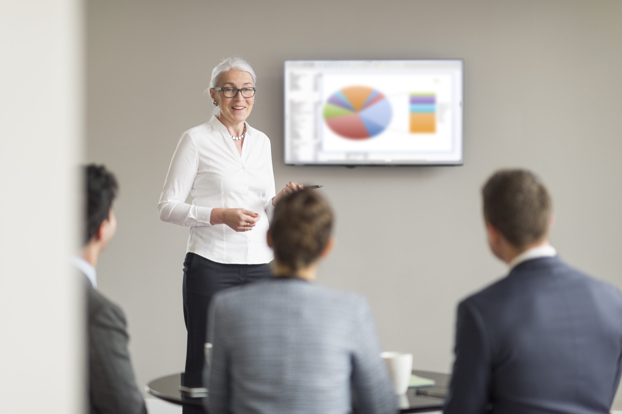 FerkoMedia - Over shoulder view of mature businesswoman giving office presentation